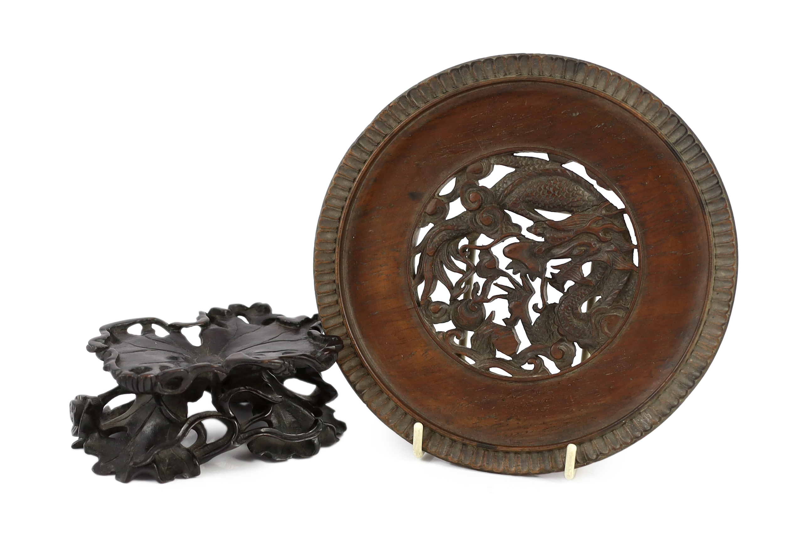 A Chinese carved wood ‘lotus’ stand and a Chinese huanghuali ‘dragon’ stand, Qing dynasty